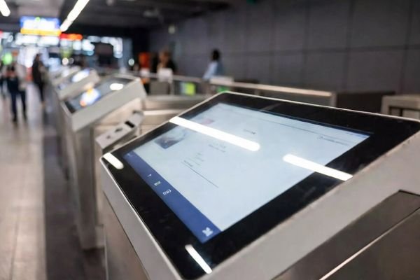 Metro station self-service terminal with a large glass-front touchscreen display showing cover glass and touch integration.