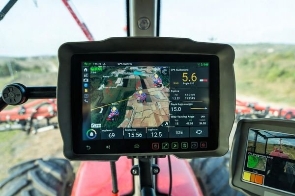 A dashboard view showing a clear, bright LCD screen displaying machine data and GPS guidance