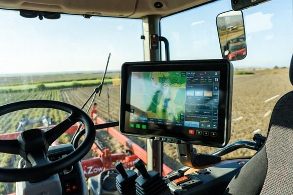 An LCD display module integrated into the armrest console of a modern agricultural tractor cabin