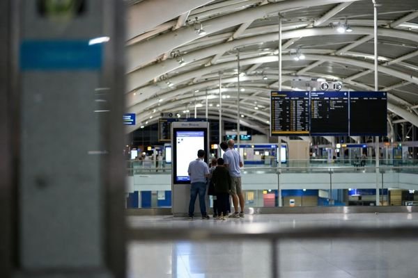 An illustration showing different viewing scenarios: a passenger looking at a large overhead display from afar, and another interacting with a smaller ticketing terminal screen up close.