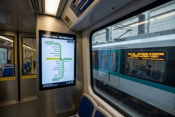 An image showing various transportation displays in action: a passenger information screen on a train platform, an ultra-wide display inside a bus, and a ticketing kiosk at a station.